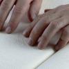 Hands reading braille.